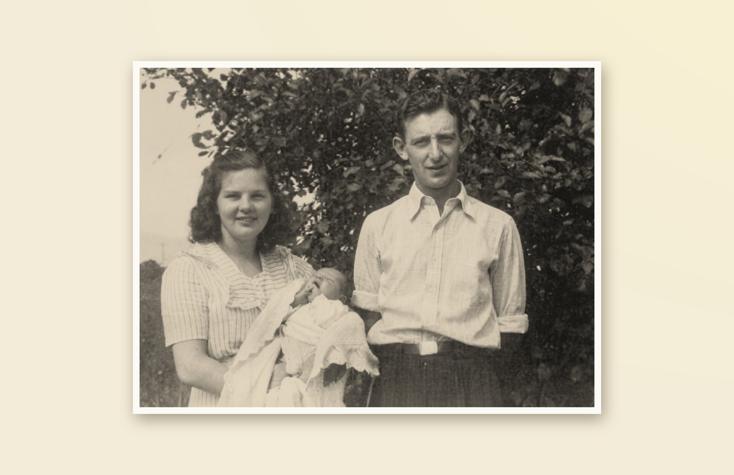A restored family portrait from Cornerstone's early years: a mother holding a swaddled baby with a father standing beside her